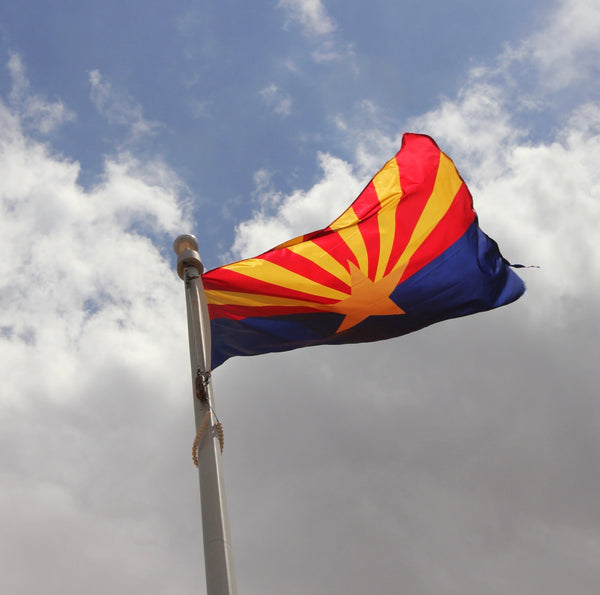 Arizona state flag with copper star and red-and-gold rays displayed outdoors at Kengla Flag Co.