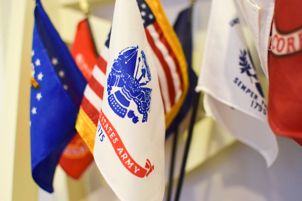 U.S. military branch flags displayed indoors for ceremonial honor at Kengla Flag Co.