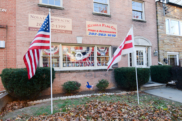Exterior of the Kengla Flag Co. storefront with American and D.C. flags displayed in front.