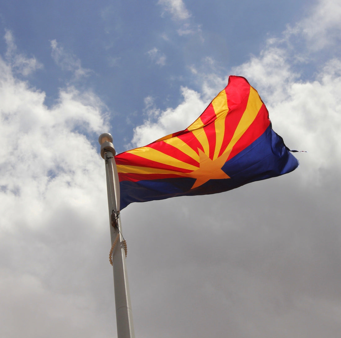 Arizona state flag with copper star and red-and-gold rays displayed outdoors at Kengla Flag Co.
