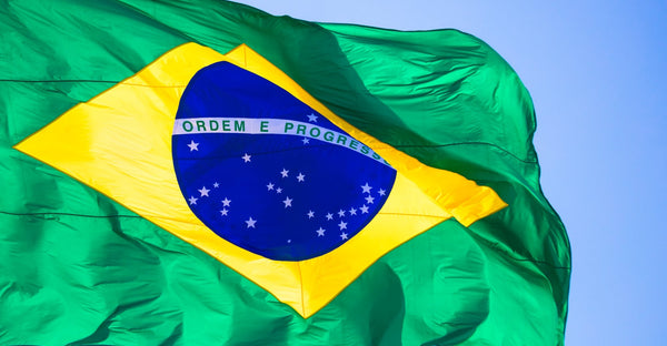 Kengla Flag Co. Brazil flag waving in the wind, showing the blue globe, stars, and “Ordem e Progresso” text.