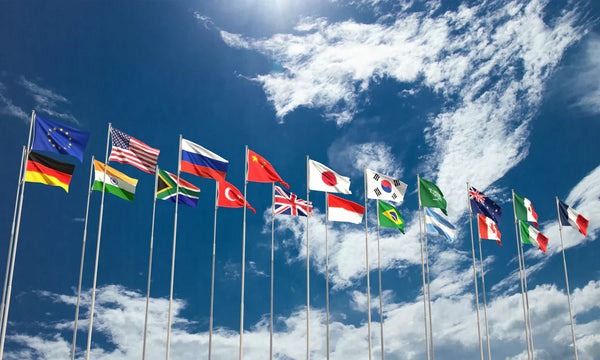 Multiple international flags, including the United States, China, and Japan, waving under a partly cloudy sky.