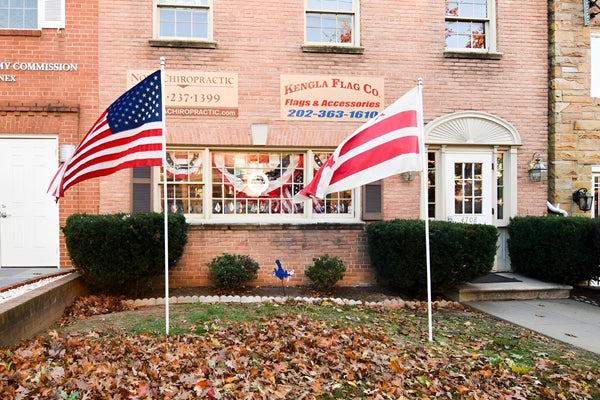 Exterior storefront of Kengla Flag Co. displaying American and Canadian flags outside the building