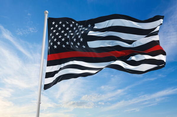 Thin Red Line flag by Kengla Flag Co., waving against a blue sky.